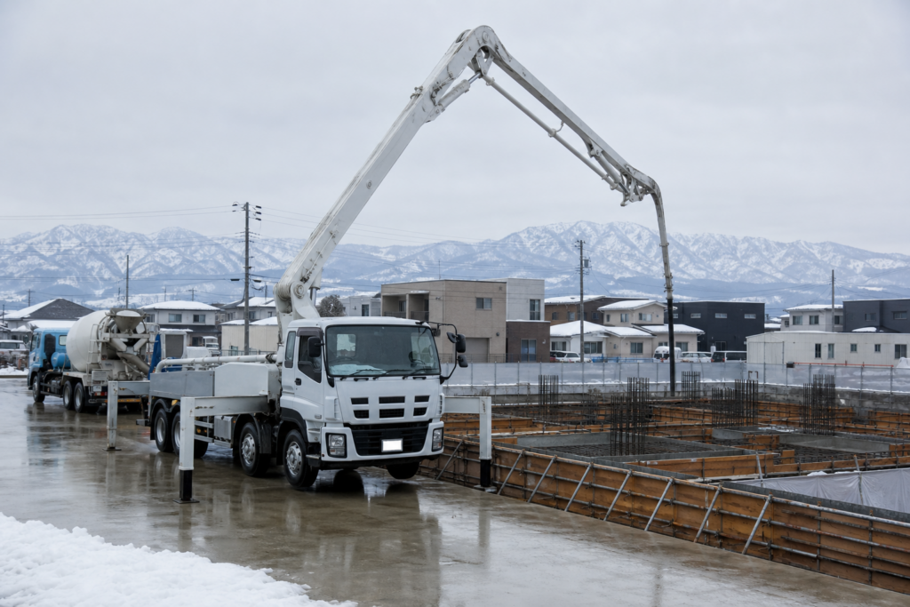 北陸のコンクリート圧送会社M&Aを想起させる冬季施工現場のポンプ車